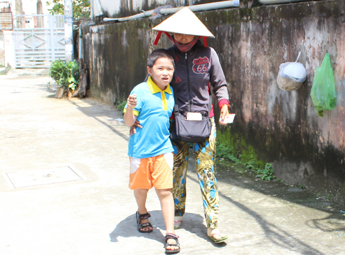 Những ngày con không lên lớp, chị Lựu lại đưa con rong ruổi đi bán vé số cùng mình. Ảnh: Lê Phương.