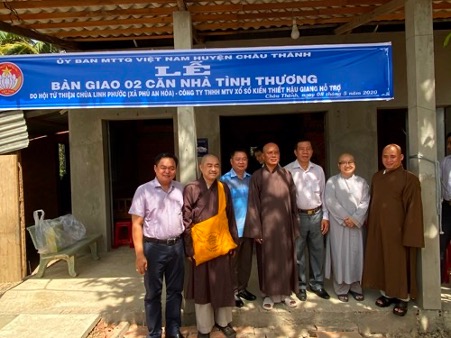 A group of people standing in front of a buildingDescription automatically generated