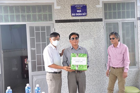 A group of people standing in a roomDescription automatically generated