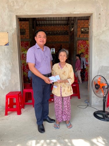 Two people standing in front of a buildingDescription automatically generated